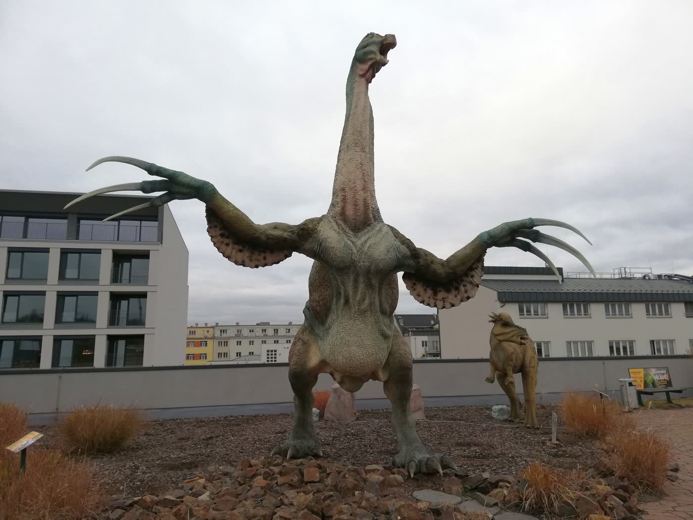 Life-sized Therizinosaurus sculpture in Prague displaying its three giant claws on outstretched arms